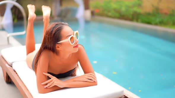 Young asian woman enjoy around outdoor swimming pool for leisure