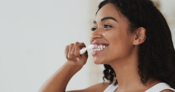 Close Up Portrait of Young African American Woman Brushing Her Teeth at Bathroom, Slow Motion