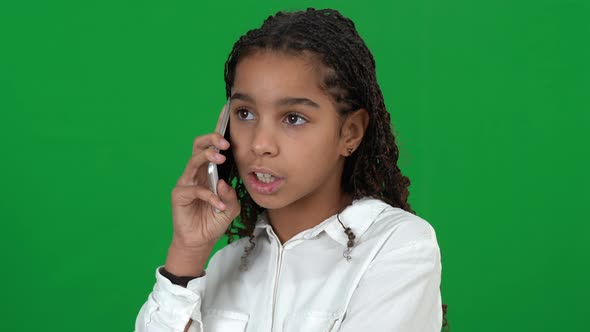 Concentrated African American Teenage Girl Talking on the Phone Laughing at Chromakey Background