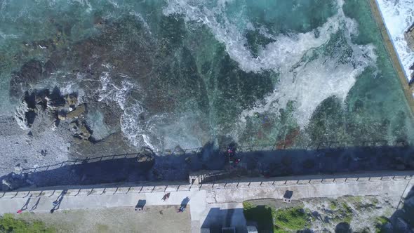 Aerial - Ascending Marine Tide Pool drone shot as waves crash into it