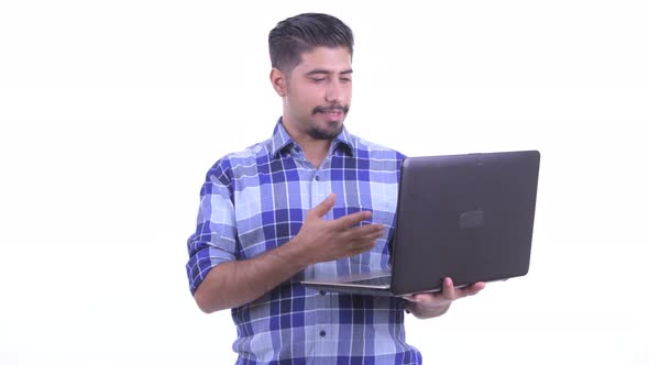 Happy Bearded Persian Hipster Man Talking While Using Laptop