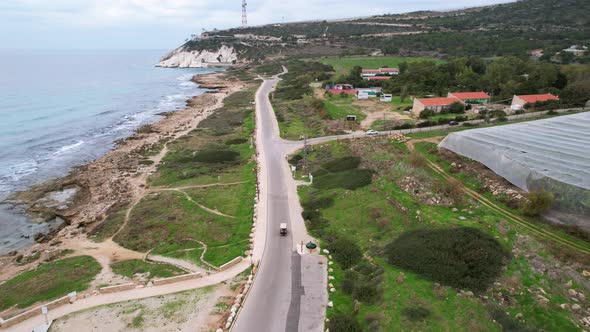 Drone shot following a Golf Car driving on a road, filmed in Rosh Hanikra, Israel