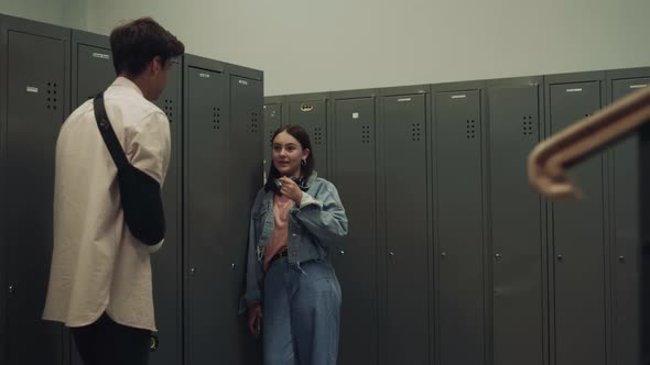 Couple Joyful Students Talking Standing at Lockers Lively School Corridor