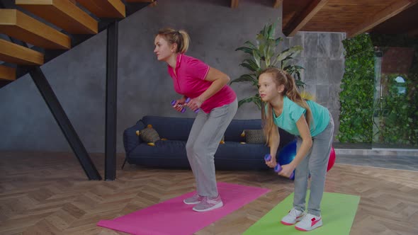 Active Fit Family Doing Bent Over Dumbbell Row Indoors