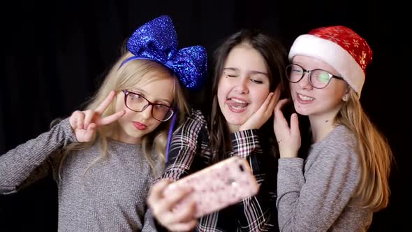 Friendship, technology and internet concept - three smiling teenage girls with smartphones