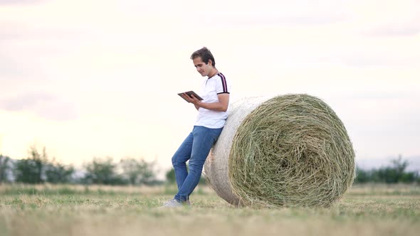 An agricultural engineer examines bales of hay.