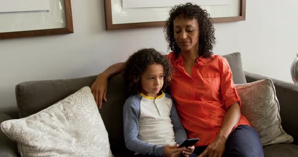 Front view of African american mother talking with her son in the lobby at hospital 4k