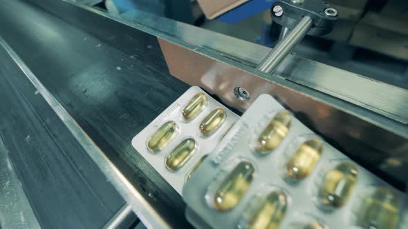 Close Up of Blisters with Fish Oil Capsules Getting Removed From the Belt