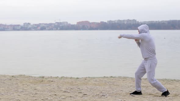 Boxing a man with an invisible opponent. A young man trains outdoors.