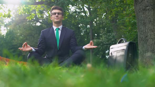 Businessman Sitting on Grass and Meditating in Fresh Air, Energy of Nature