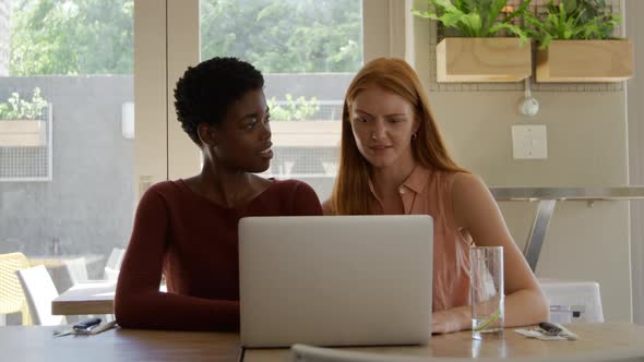 Young adult female friends hanging out in a cafe