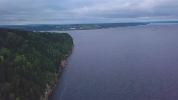 Aerial View of the Steep Cliff Above the Calm River Surface