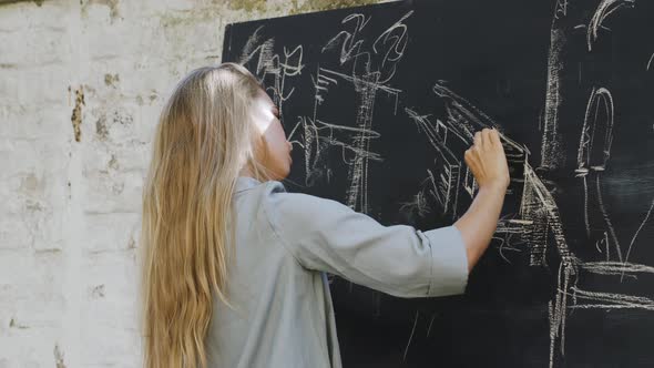 Portrait of beautiful blonde woman drawing