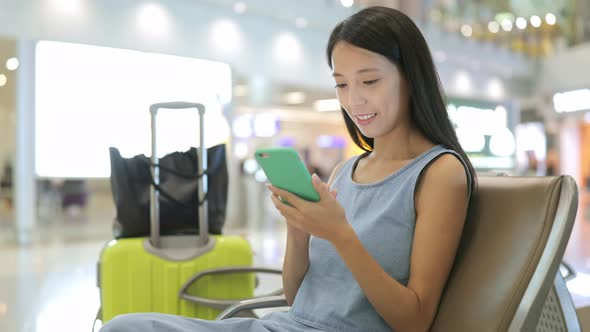 Woman Using Cellphone in Airport