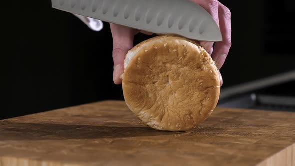 Professional chef puts sliced hamburger buns on hot burger pan. Street fast food