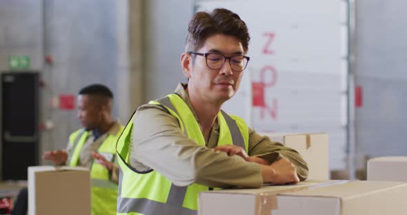 Portrait of asian male worker wearing safety suit and smiling in warehouse