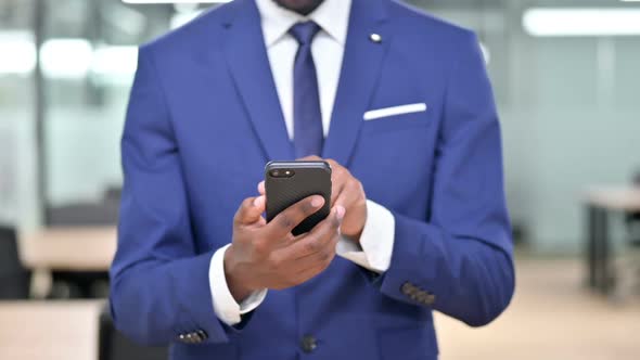 African Businessman Using Smartphone at Work