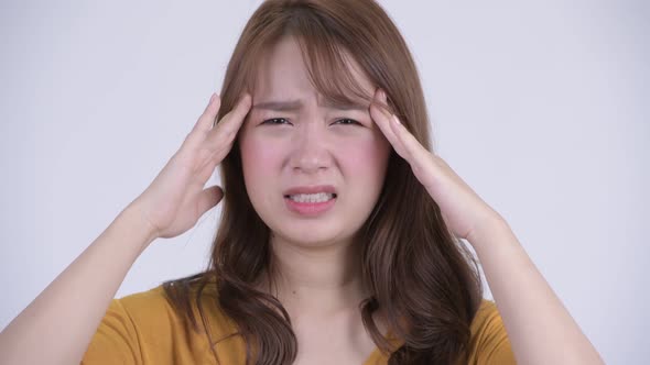 Face of Young Stressed Asian Woman Having Headache