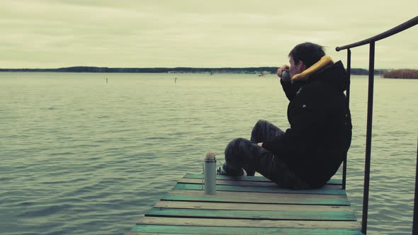 Man on Pier Drinking Tea