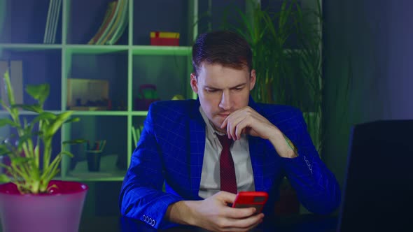 Thoughtful Businessman Using Mobile Phone in Modern Workplace