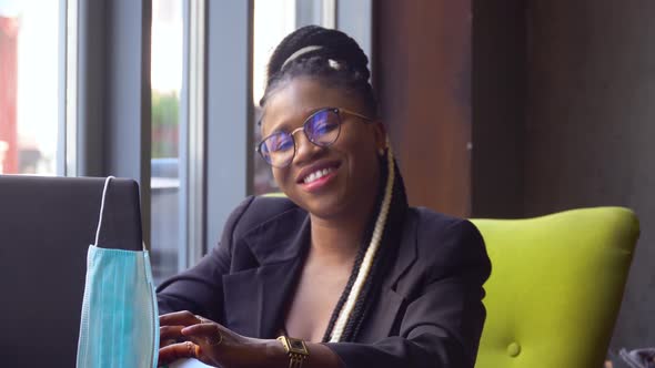 Young Black Woman Use Laptop and Looking at the Camera