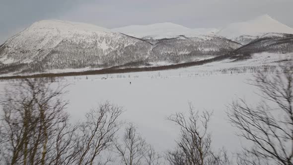 A Tiny Silhouette Of A Man Skiing Through Snow Field In Oldervikdalen, Norway. - Wide Shot