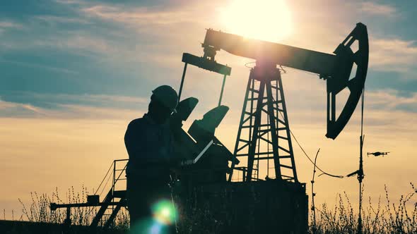 Engineer with Laptop Walking About Oil Pumpjack Drone Flying