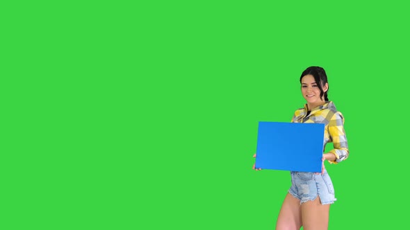 Young Charming Brunette Model Holding Empty Board on a Green Screen, Blue Mockup.