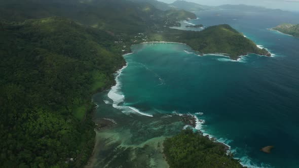 Aerial dolly over Anse Souillac beach to Port Launay Marine Park, Mahe