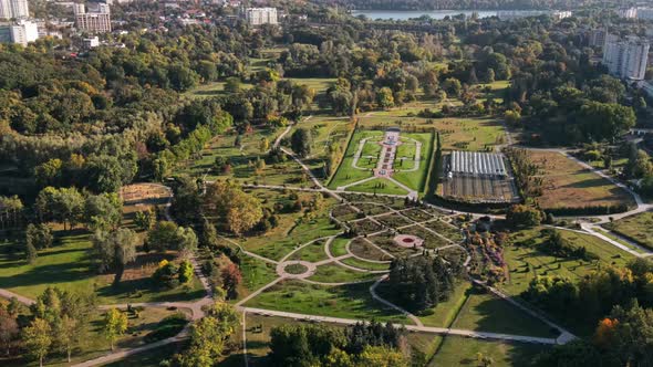 Aerial drone view of Chisinau at sunset. Panorama view of a park with lush trees and lake