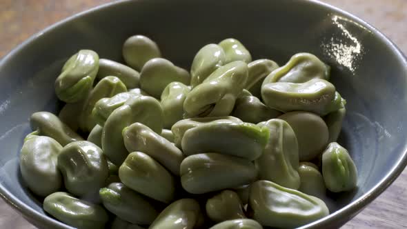 Fava beans that have been boiled so the skin looks like it is loose and ready to be peeled off.