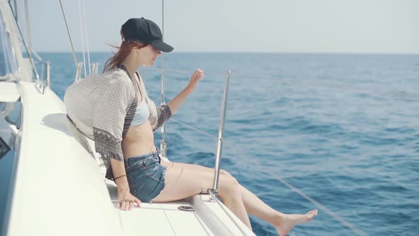 Beautiful Woman on a Yacht Enjoys the Journey on the Background of the Islands of Ibiza or Mallorca