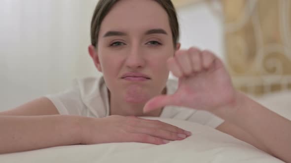 Close Up of Beautiful Woman Doing Thumbs Down in Bed 