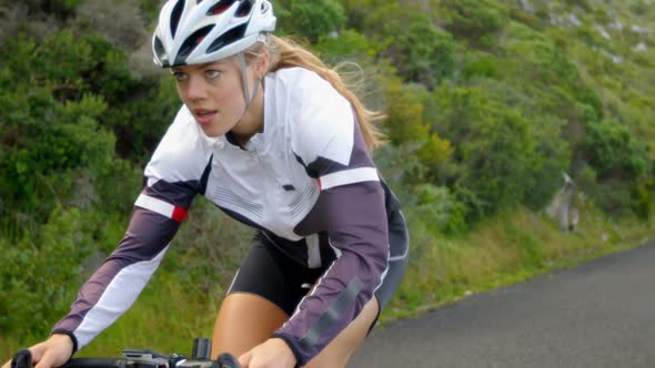 Female cyclist cycling on a countryside road