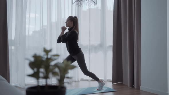 Sporty Young Woman Doing Squat Morning Exercise Alone in Living Room, Serious Fit Girl Wearing