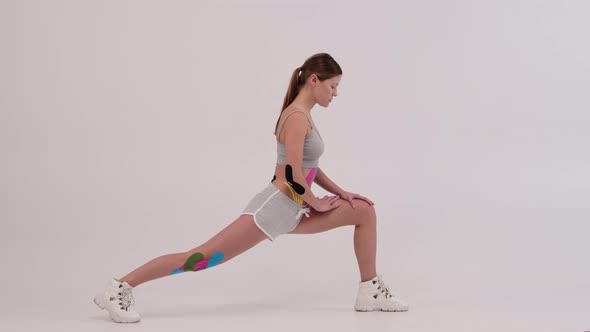 fit women with kinesiotaping on her body doing fitness and stretching. Health and fitness concept.