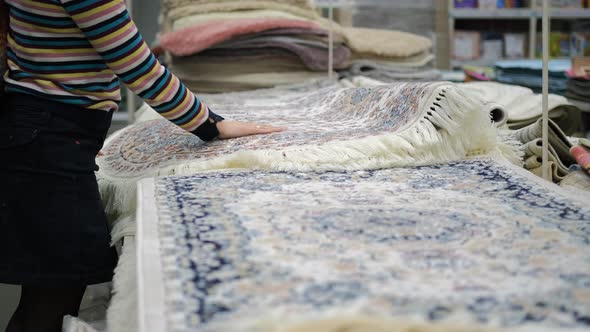 Woman Choosing Carpet in a Furniture Store