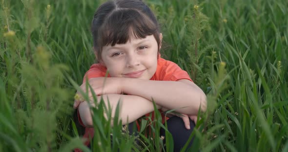 Child Sit and Relax in the Green Grass