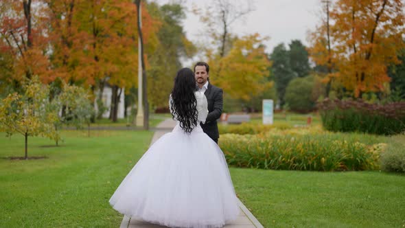 Loving Man and Woman are Celebrating Their Wedding Walking Together in Autumn Park