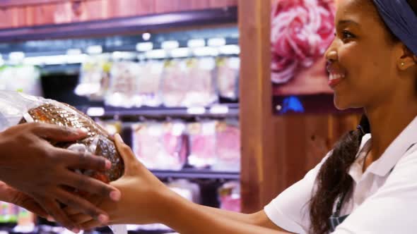 Smiling female staff giving a goods to customer