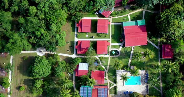 Top down view of red roofs, green landscape and pool of hotel ecologico Loma Pan de Azucar, Monte Pl