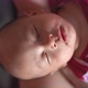 Asian baby sleeping in mother's arms - VideoHive Item for Sale
