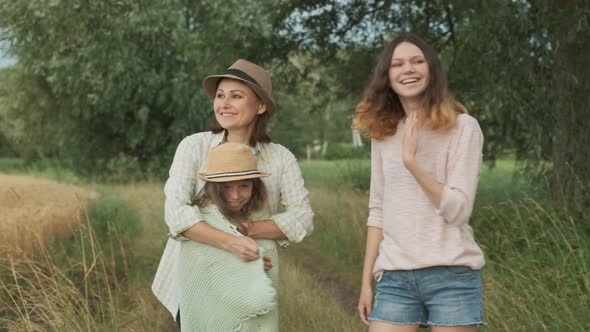 Family Mother and Daughters Walking Together Along Country Road