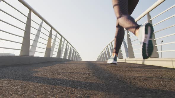 Young woman running on a bridge