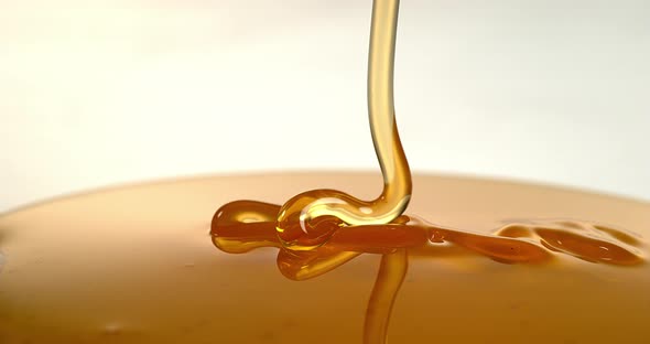 Honey Flowing against White Background, Slow Motion 4K