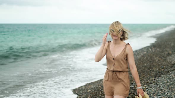 Cheerful Attractive Blonde with a Square in Glasses Walks Along the Waterfront Wind Develops Her