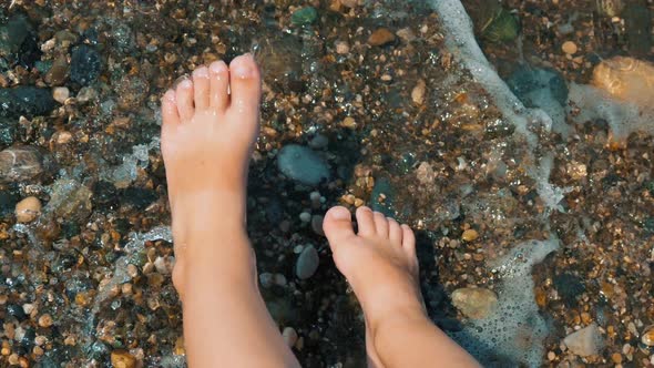 Young Child Legs in the Fast Water Flow at Sea Beach