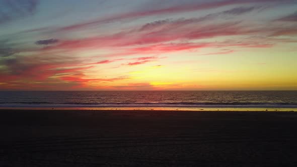 Aerial drone view of a sunset at the beach over the ocean