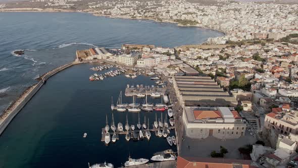 Harbor with boats and cityscape of Chania city, aerial drone view