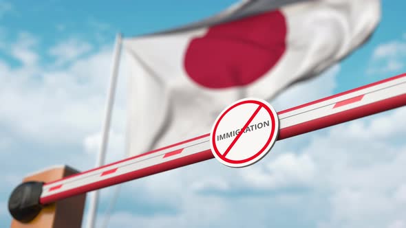 Barrier Gate with No Immigration Sign Opened at Flag of Japan